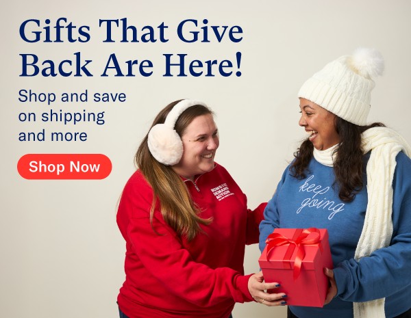 A photo of two people wearing Everytown and Moms Demand Action Merch, with a present box between them. Words on the image read: Gifts That Give Back Are Here! Shop and save on shipping and more. and a button that reads "Shop Now"